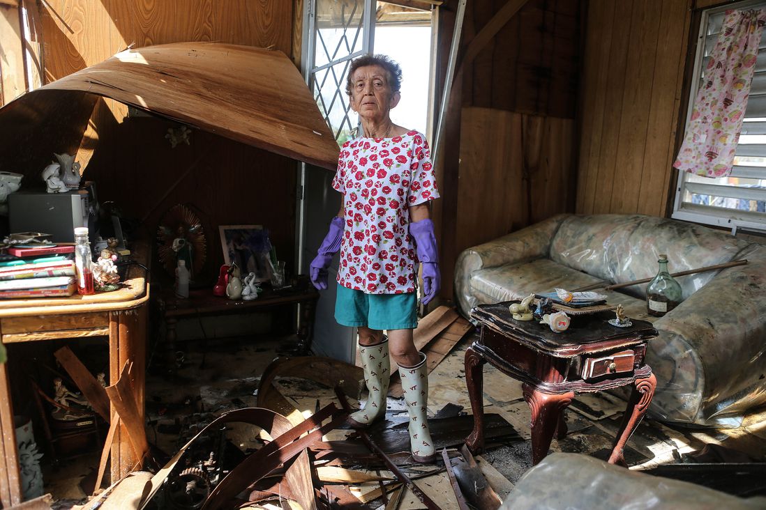Sonia Torres, 60, poses in her destroyed home while taking a break from cleaning, three weeks after Hurricane Maria hit the island, on October 11, 2017 in Aibonito, Puerto Rico. <br/>